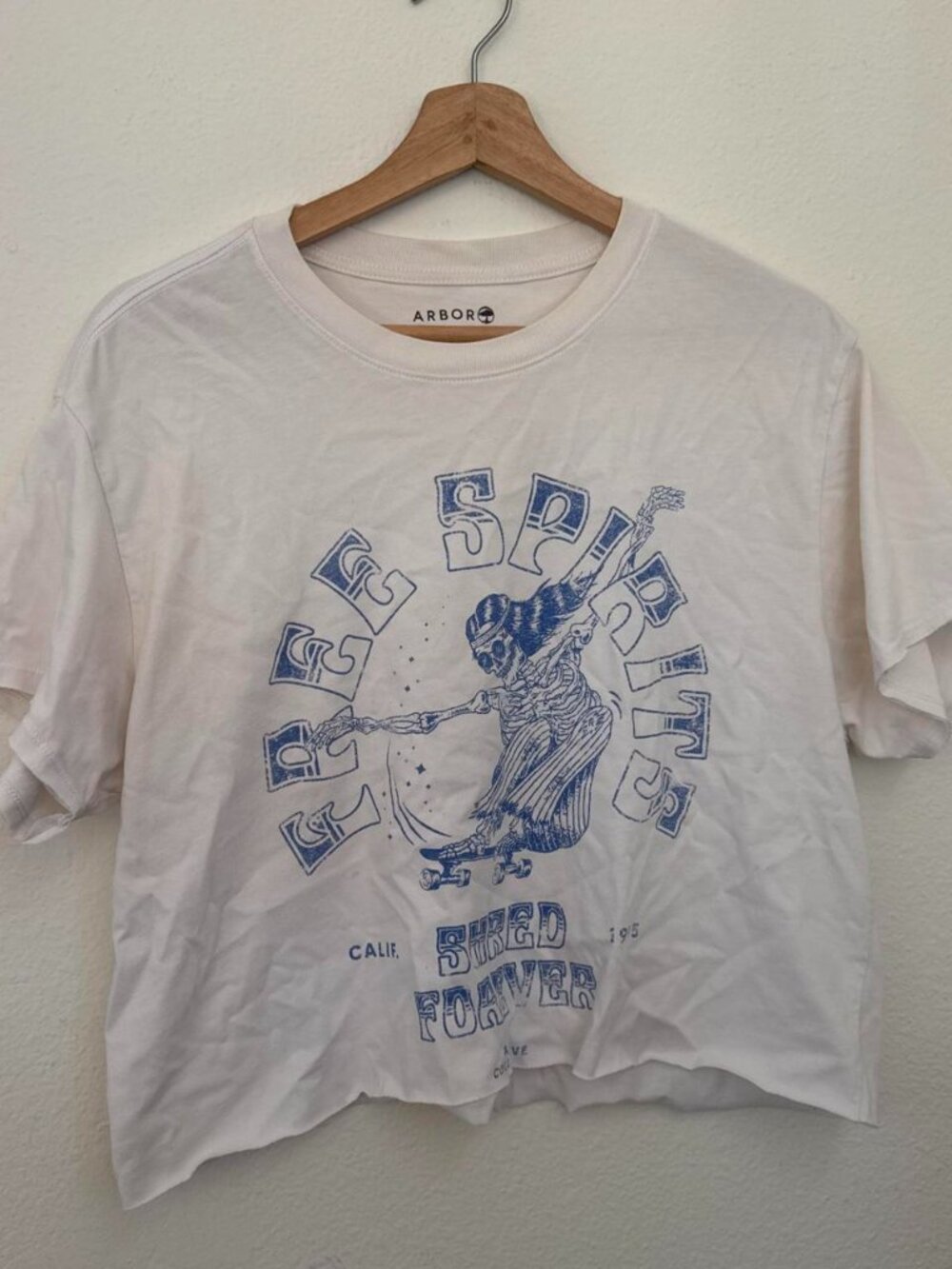 Arbor white cotton t-shirt with blue graphic of a person with a guitar and the